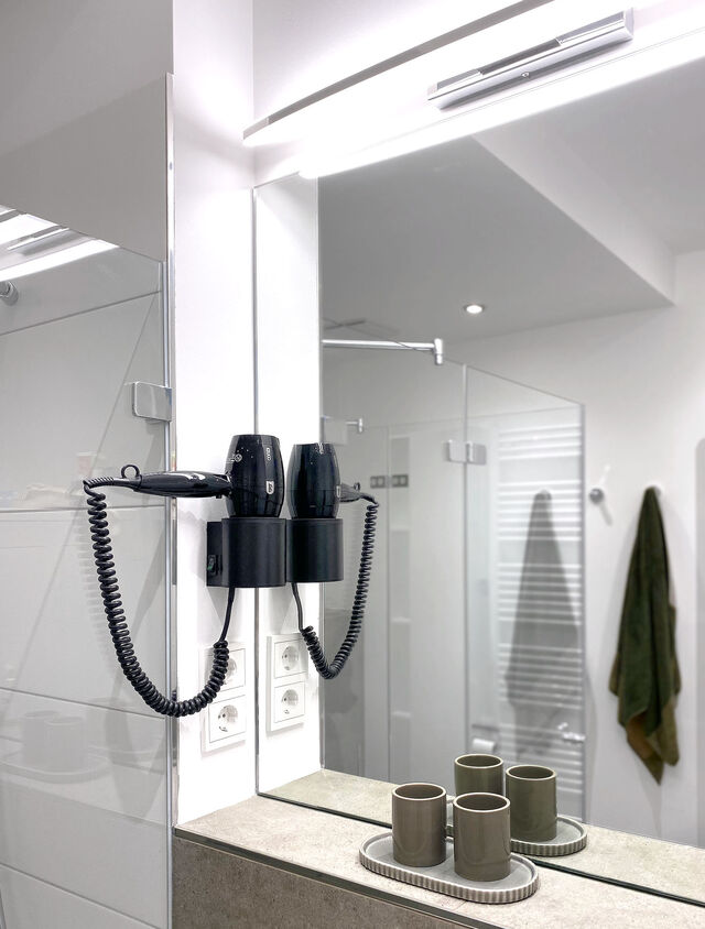 Moderner Badspiegel mit LED-Beleuchtung, wandmontiertem F&ouml;hn und elegantem Keramik-Bad-Accessoire-Set im m&ouml;blierten Apartment Bamberg